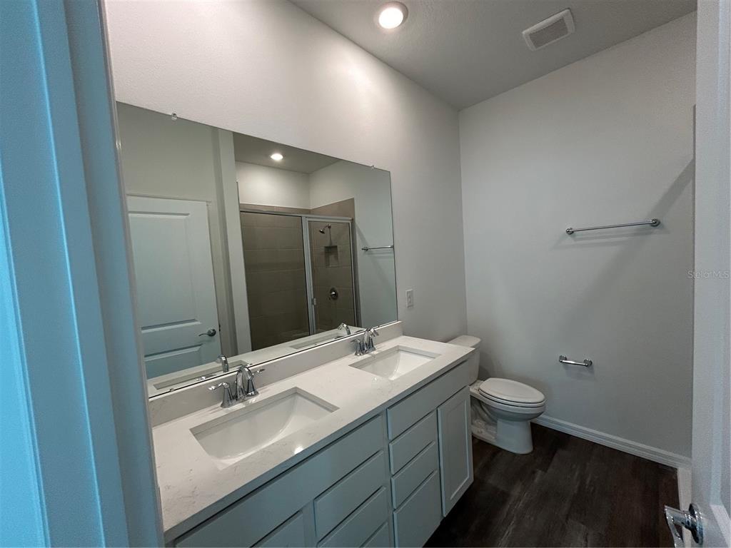32746 Rustic Rise Road San Antonio, FL 33576 - Photo 11 of 24 a bathroom with a granite countertop sink toilet and mirror