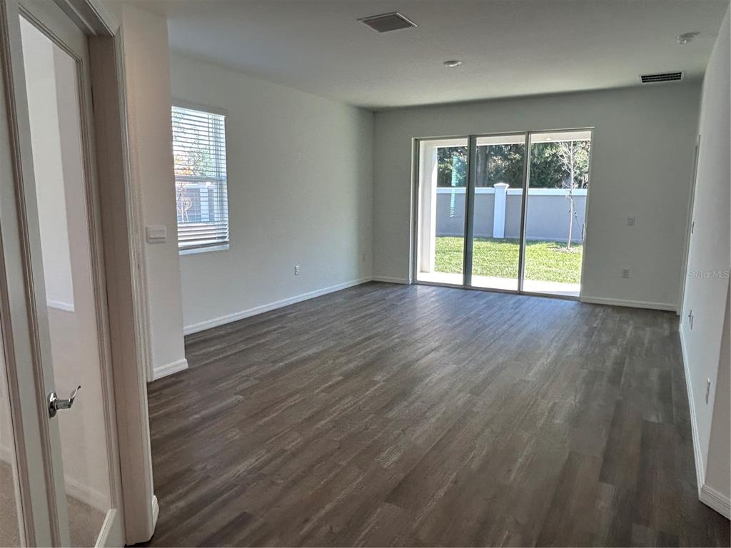 32746 Rustic Rise Road San Antonio, FL 33576 - Photo 16 of 24 a view of an empty room with wooden floor and a window