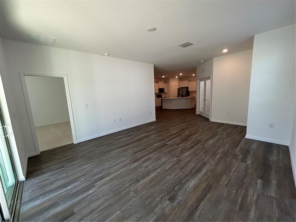32746 Rustic Rise Road San Antonio, FL 33576 - Photo 7 of 24 a view of a big room with wooden floor and windows