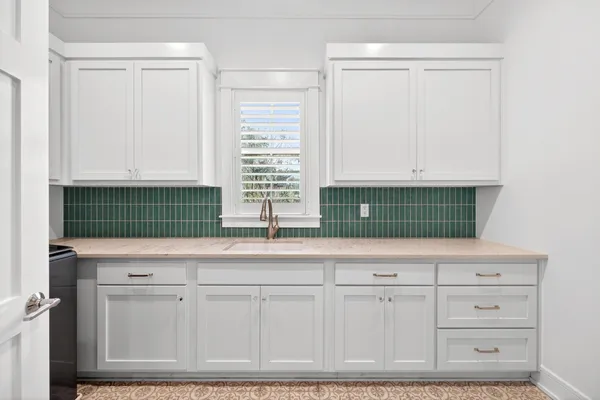 a kitchen with white cabinets and a fireplace
