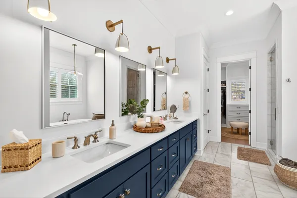 a bathroom with a sink double vanity granite tub shower and a mirror