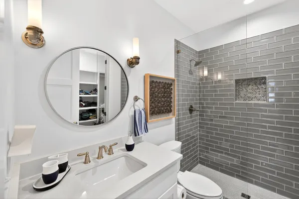 a bathroom with a sink a toilet and a mirror