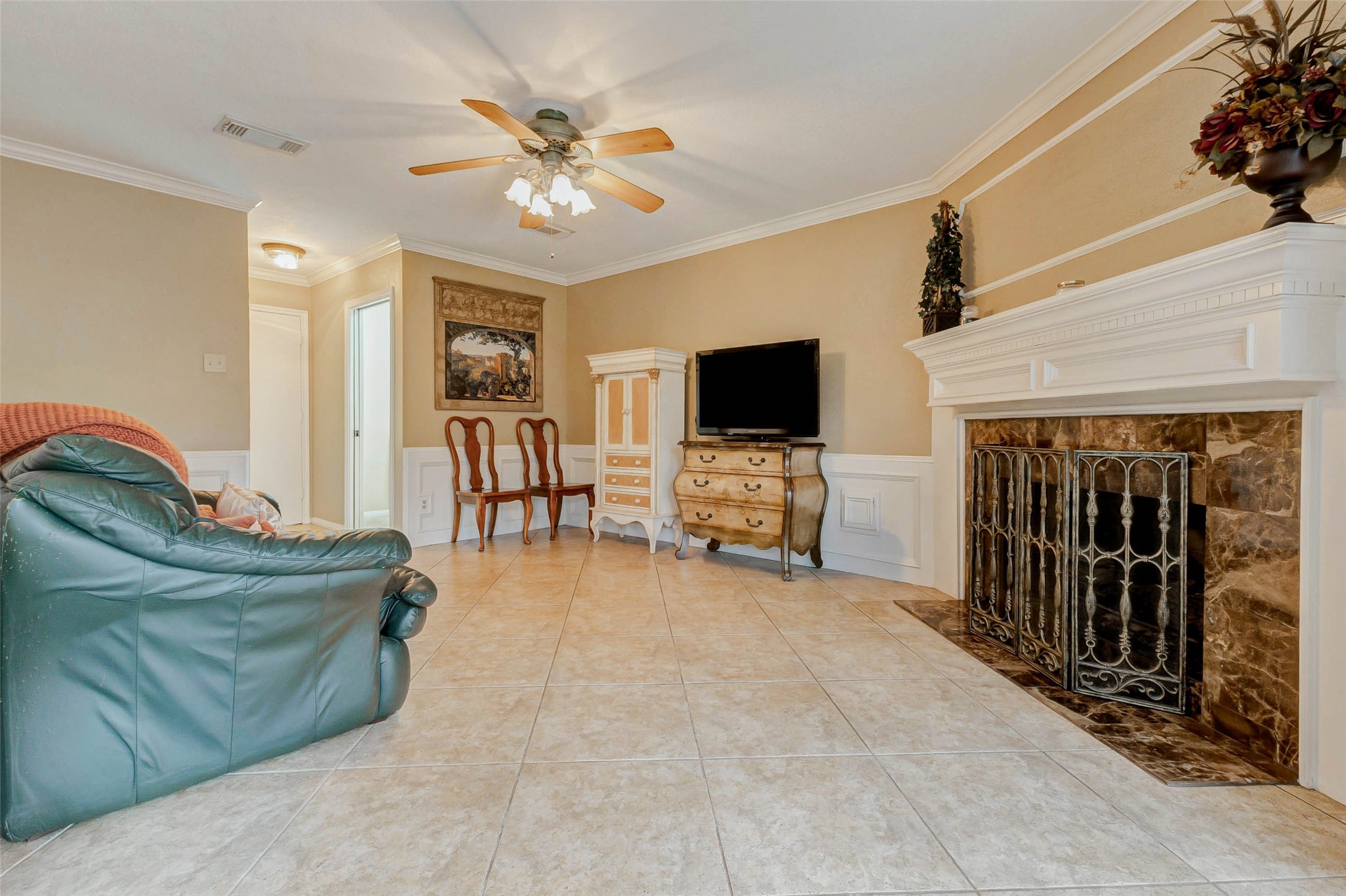 15811 Spring Forest Drive Houston, TX 77059 - Photo 11 of 27 Discover a cozy den off the kitchen, featuring elegant tile flooring, a charming fireplace, and abundant natural light—perfect for relaxation or entertaining.