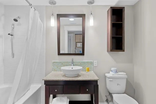 a bathroom with a toilet a sink and mirror