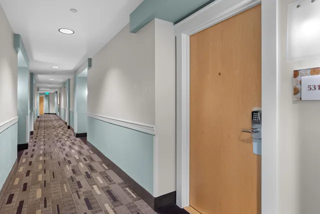 a hallway with a large mirror and wooden floor