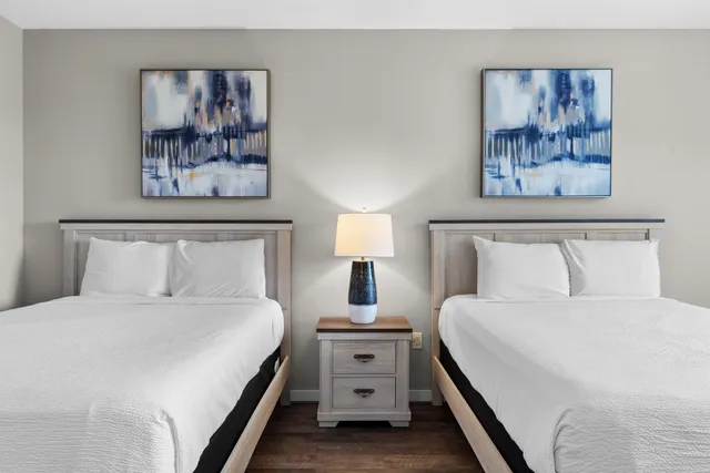 a bedroom with a bed and painting on the wall