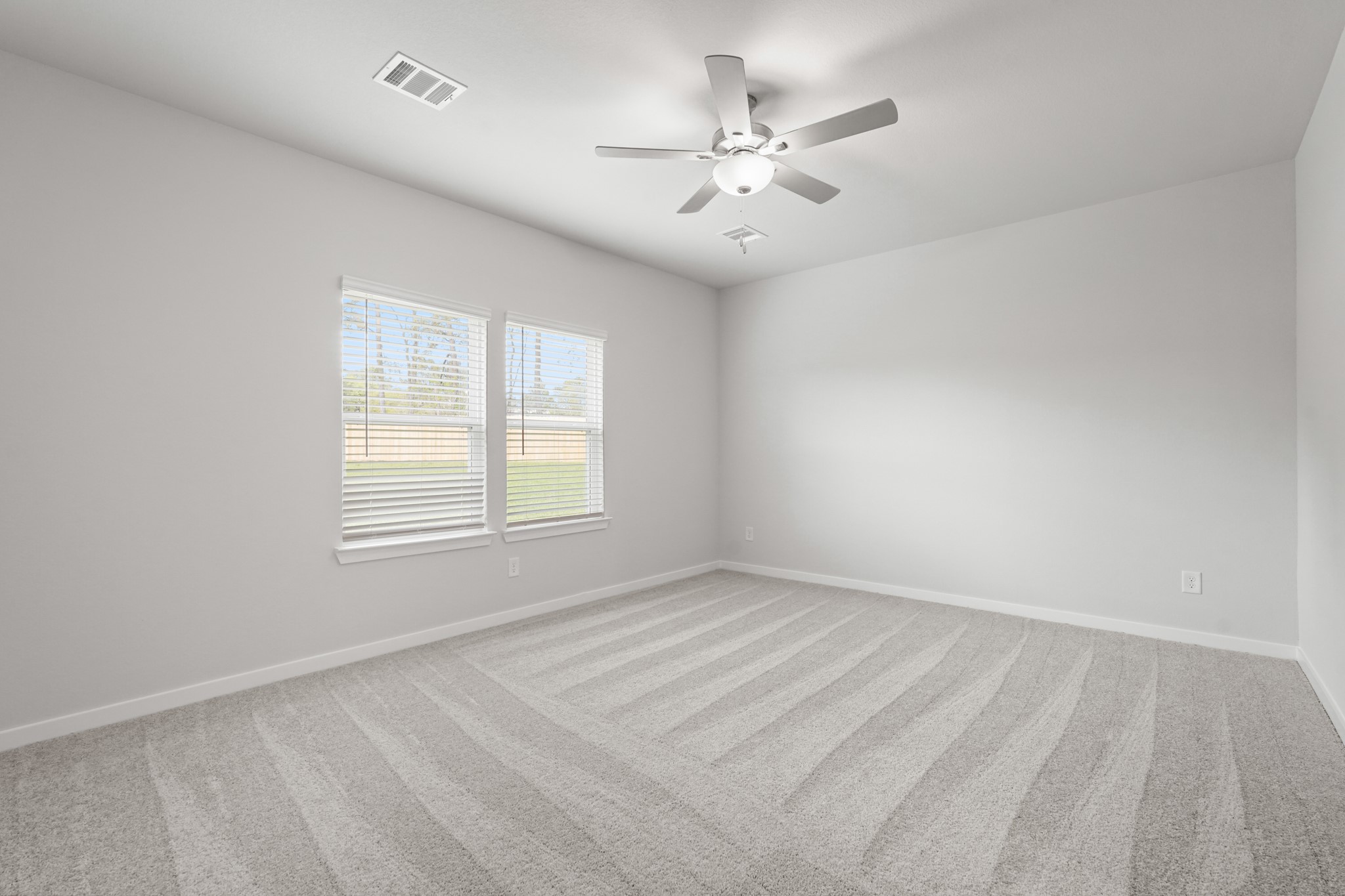217 Spring Drive Hockley, TX 77447 - Photo 13 of 27 an empty room with chandelier fan and windows