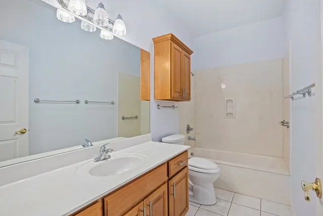 a bathroom with a granite countertop sink a toilet a mirror and shower