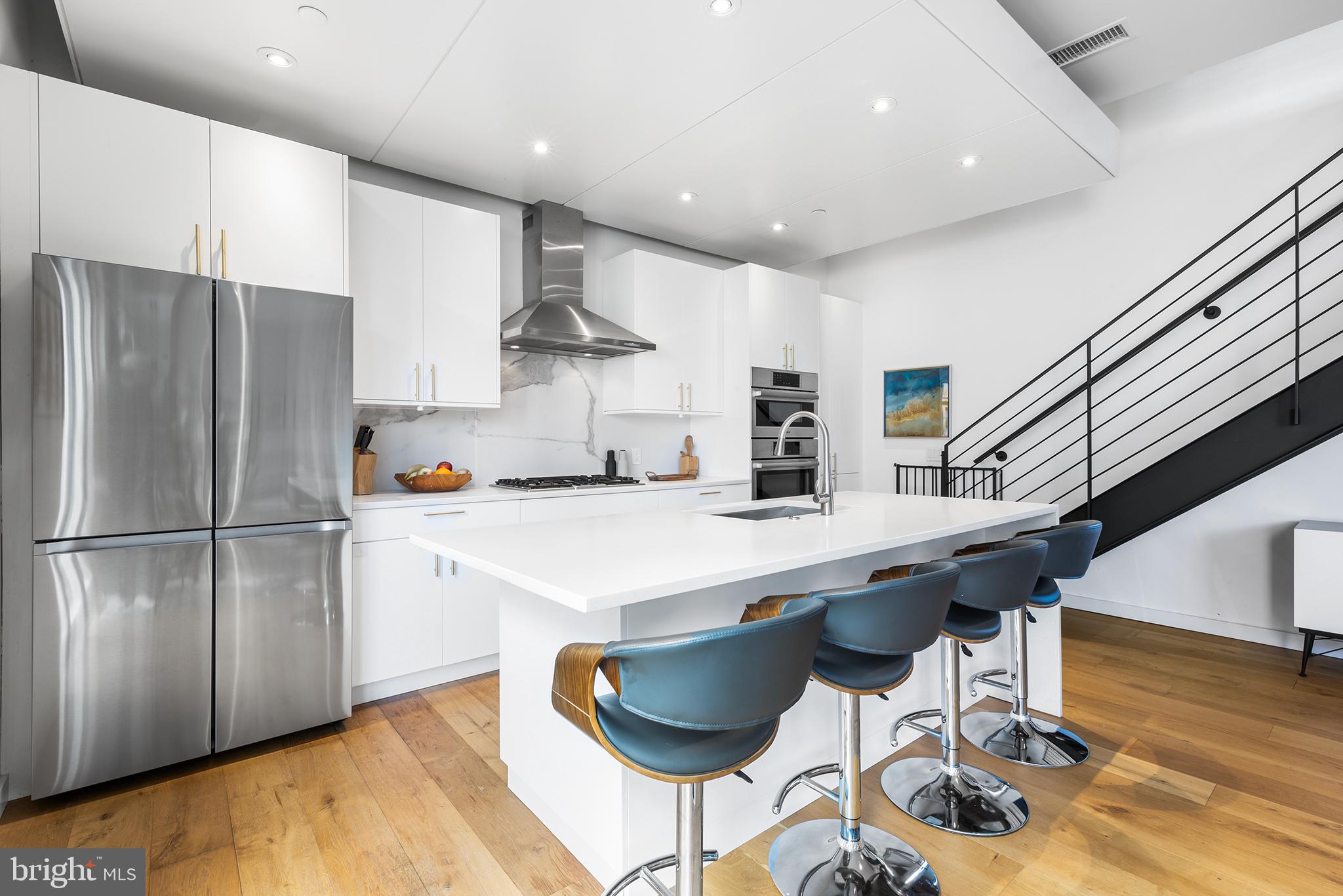 1124 Shackamaxon Street, Unit 8 Philadelphia, PA 19125 - Photo 12 of 41 a kitchen with stainless steel appliances granite countertop a refrigerator a sink a stove a dining table and chairs