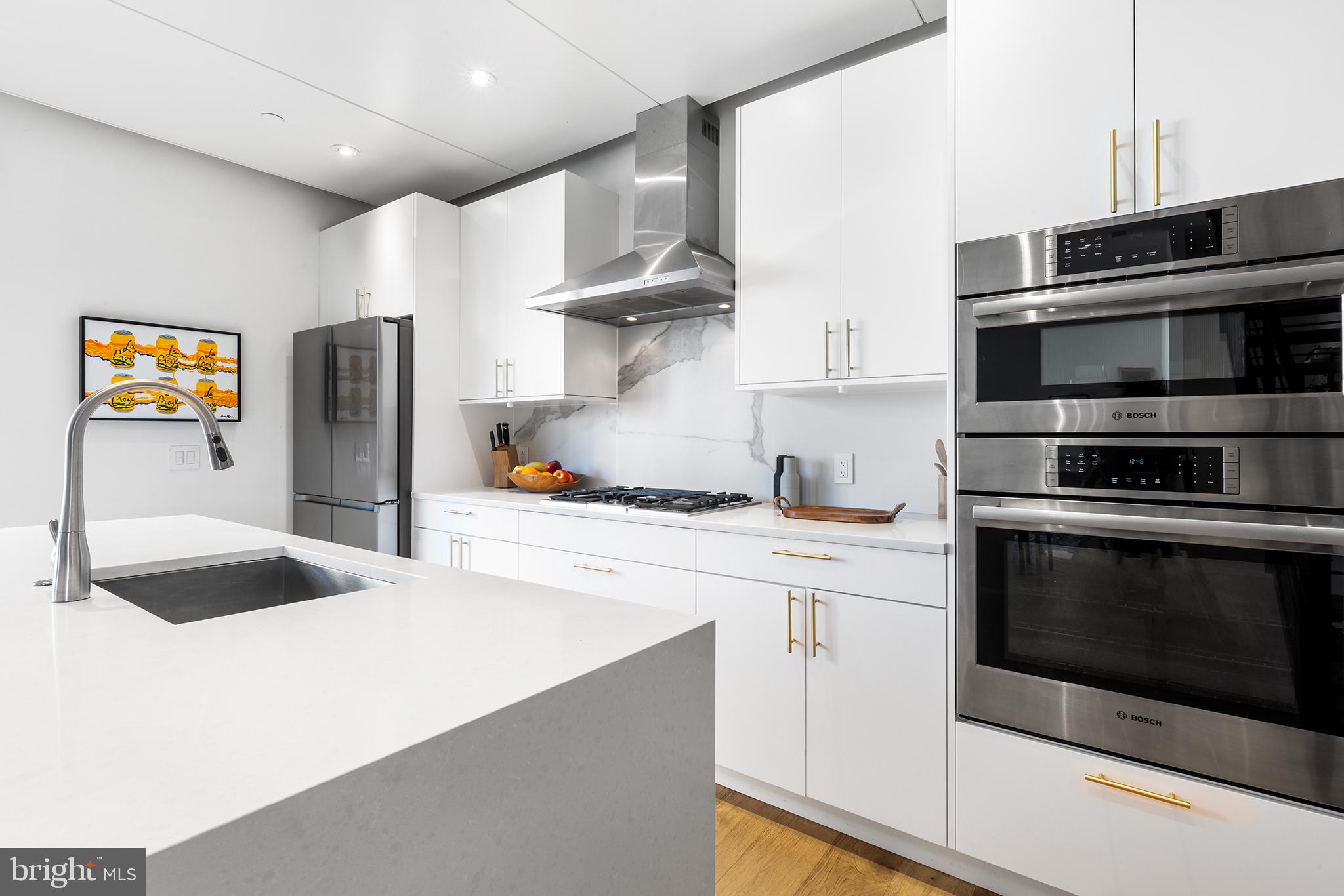 1124 Shackamaxon Street, Unit 8 Philadelphia, PA 19125 - Photo 15 of 41 a kitchen with stainless steel appliances a stove a microwave and a refrigerator