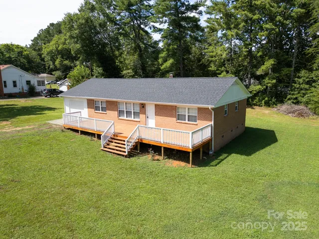 a aerial view of a house with a yard table and chairs in patio