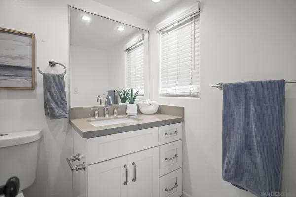 a bathroom with a sink a toilet and a mirror