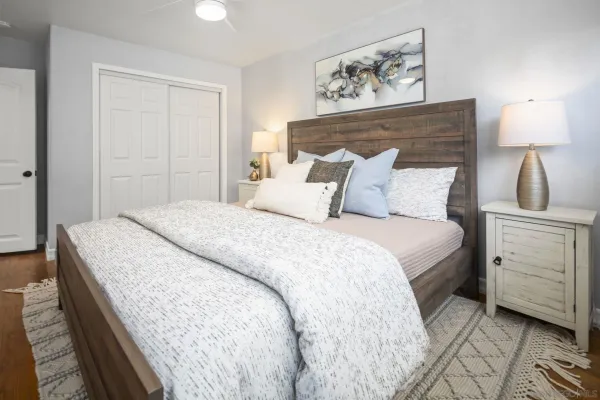 a bedroom with a bed and a lamp on dresser