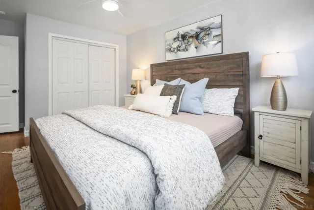 a bedroom with a bed and a lamp on dresser