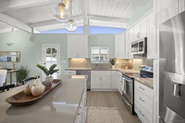 a kitchen with stainless steel appliances kitchen island granite countertop a sink dishwasher stove and refrigerator with wooden floor