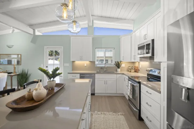 a kitchen with stainless steel appliances kitchen island granite countertop a sink dishwasher stove and refrigerator with wooden floor