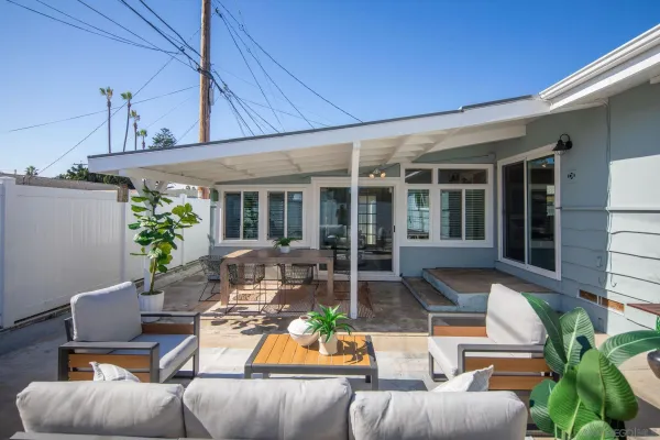 a view of a patio with couches table and chairs with potted plants