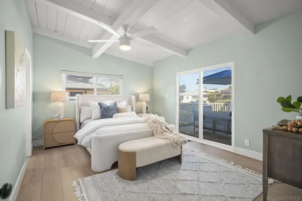 a spacious bedroom with a bed and glass door