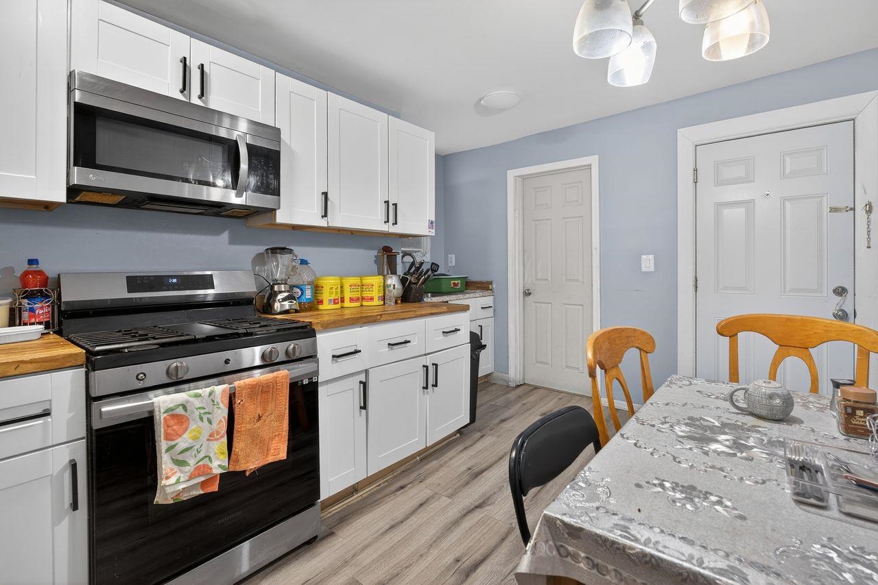 229 Patterson Street Harrison, NJ 07029 - Photo 4 of 26 a kitchen with stainless steel appliances a stove a sink cabinets and a dining table