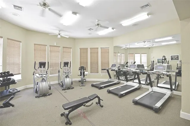 a room with gym equipment and large windows