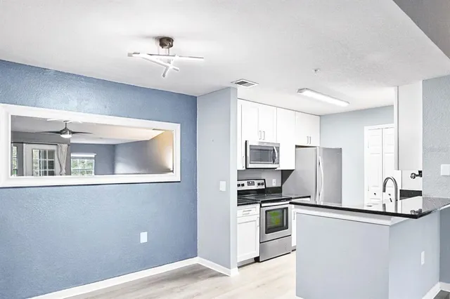 a kitchen with stainless steel appliances kitchen island granite countertop a refrigerator and a stove top oven