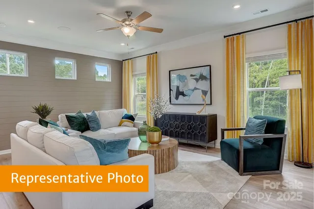 a living room with furniture a large window and a chandelier