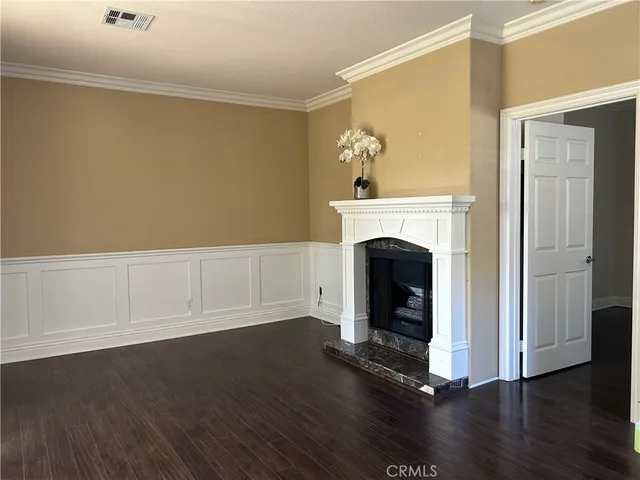 a view of a livingroom with wooden floor and a fireplace