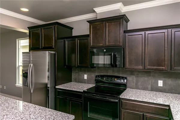 a kitchen with granite countertop stainless steel appliances and wooden cabinets