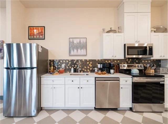 a kitchen with a stove a refrigerator and a cabinets