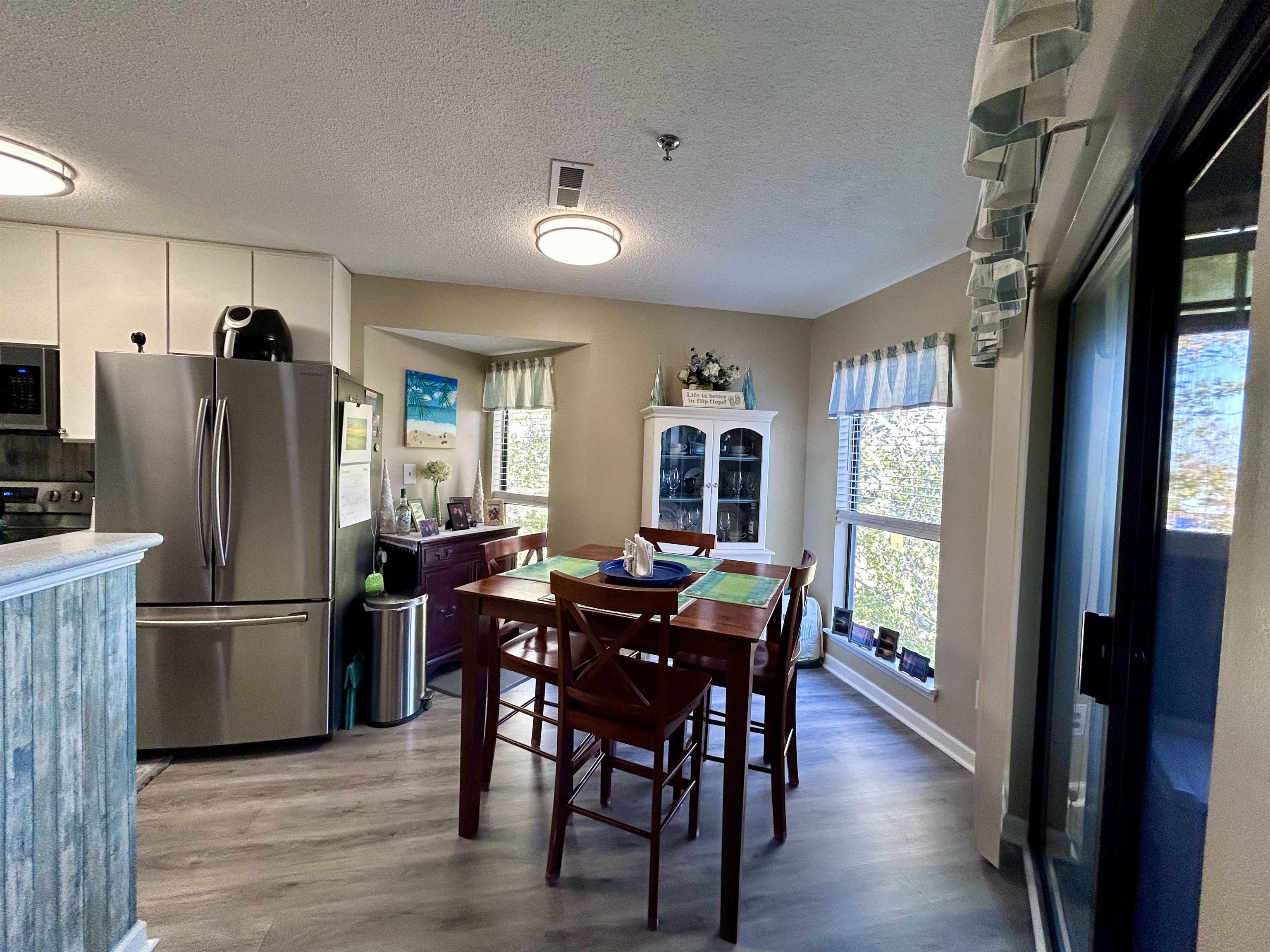 1101 Possum Trot Road, Unit B302 North Myrtle Beach, SC 29582 - Photo 11 of 22 Dining area featuring hardwood / wood-style floors, a textured ceiling, and a wealth of natural light