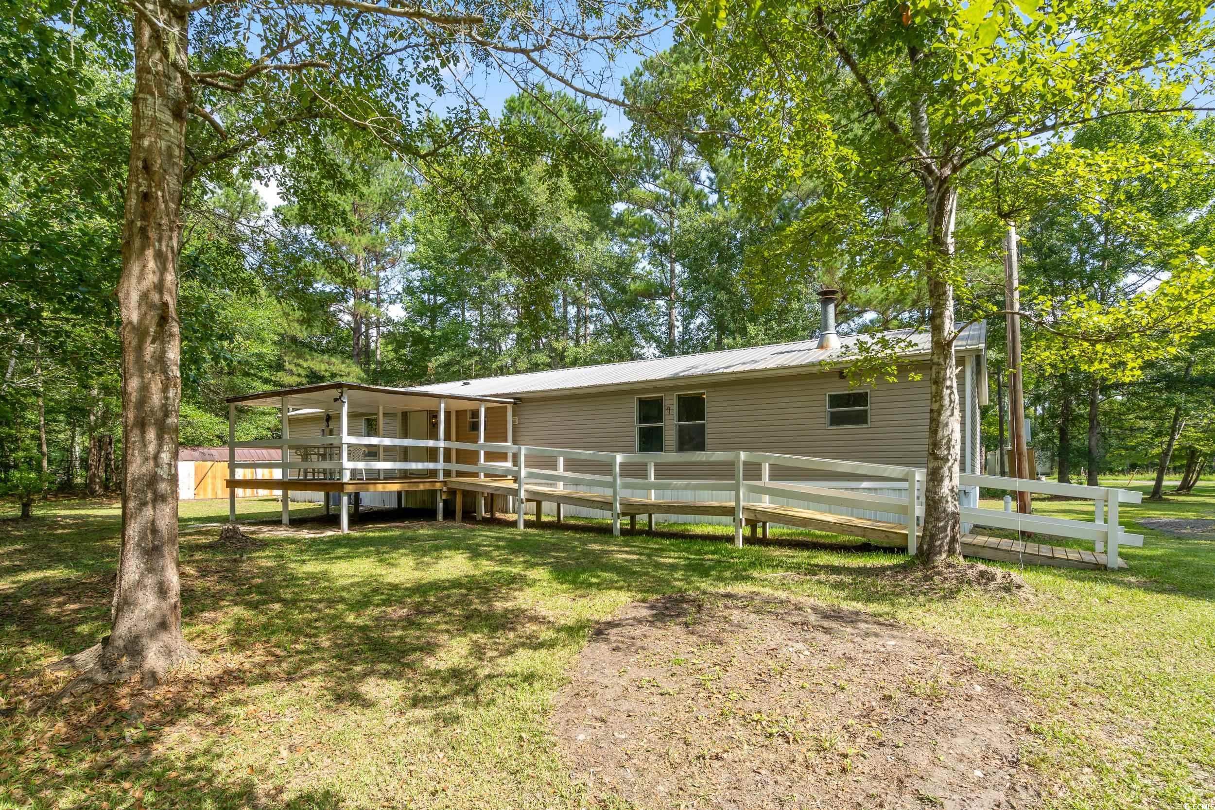 Rear view of property with a deck and a lawn