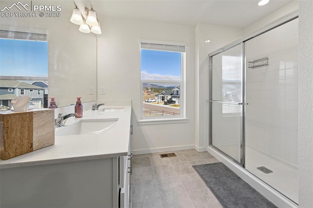 15945 Little Bluestem Road Monument, CO 80132 - Photo 13 of 49 a bathroom with a double vanity sink mirror and shower