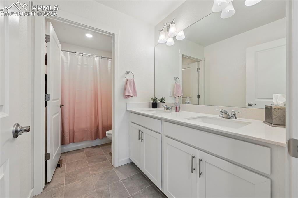15945 Little Bluestem Road Monument, CO 80132 - Photo 19 of 49 a bathroom with a double vanity sink a mirror and shower