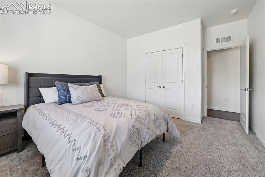 15945 Little Bluestem Road Monument, CO 80132 - Photo 21 of 49 a bedroom with a bed and a night stand