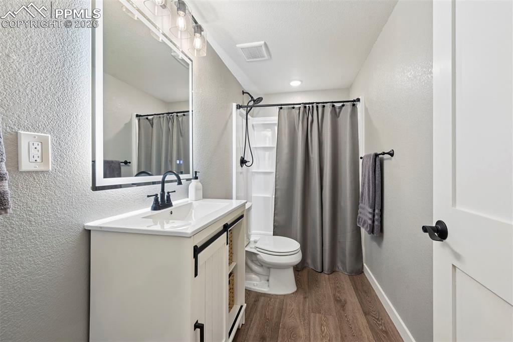 15945 Little Bluestem Road Monument, CO 80132 - Photo 30 of 49 a bathroom with a sink a toilet a mirror and shower