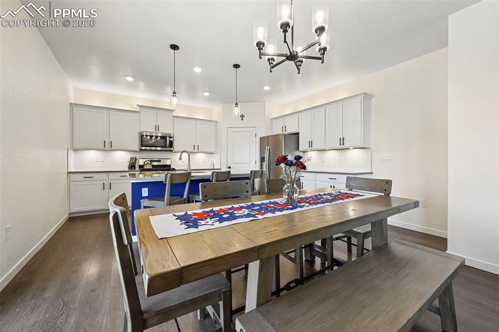 15945 Little Bluestem Road Monument, CO 80132 - Photo 5 of 49 a kitchen with kitchen island a stove a table and chairs in it