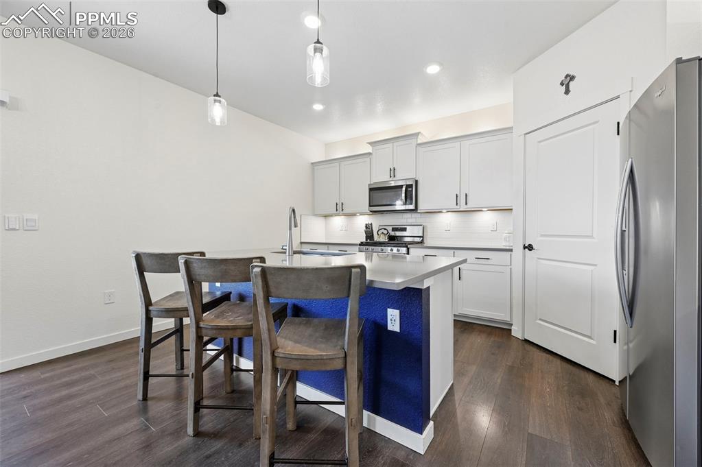 15945 Little Bluestem Road Monument, CO 80132 - Photo 9 of 49 a kitchen with kitchen island granite countertop a sink a center island a counter space stainless steel appliances and cabinets