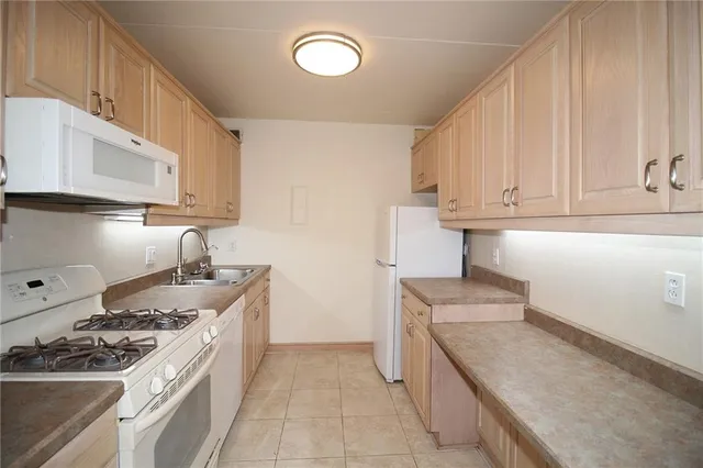 a kitchen with granite countertop a sink stove and cabinets