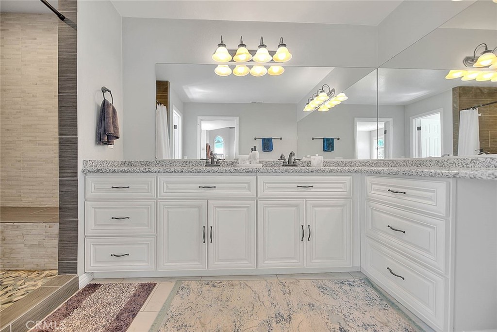 750 Jericho Drive Fallbrook, CA 92028 - Photo 48 of 74 a spacious bathroom with a granite countertop sink a mirror and a