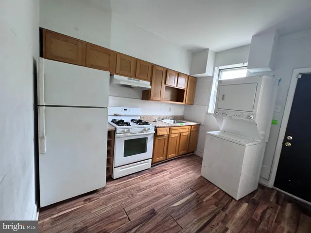 a kitchen with a white stove top oven and refrigerator