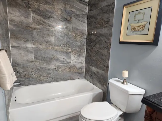 a white toilet sitting next to a bath tub