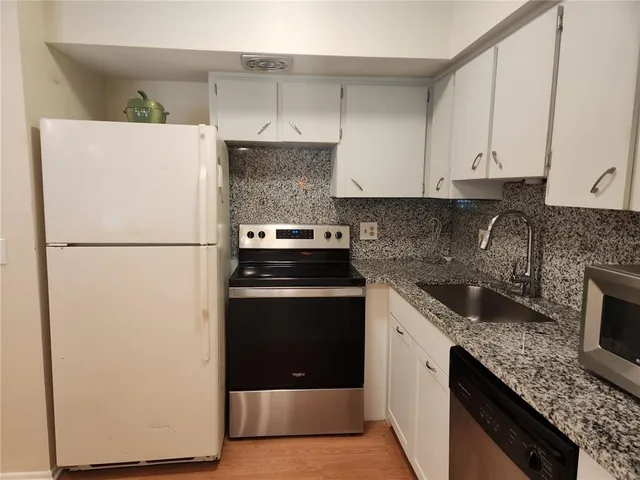 a kitchen with a refrigerator and a sink
