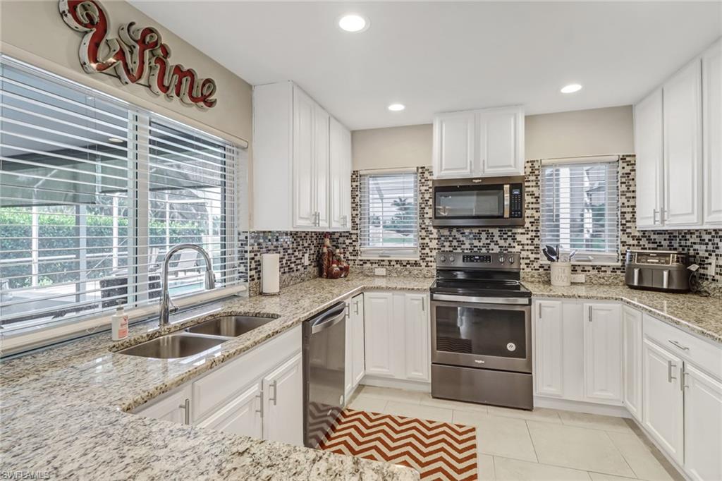 148 Pebble Beach Boulevard Naples, FL 34113 - Photo 1 of 24 a kitchen with a sink stove top oven and refrigerator