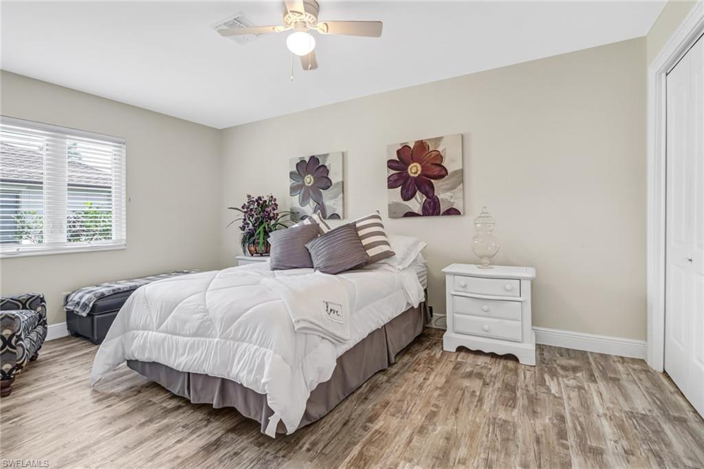 148 Pebble Beach Boulevard Naples, FL 34113 - Photo 16 of 24 a bedroom with a bed and a chandelier