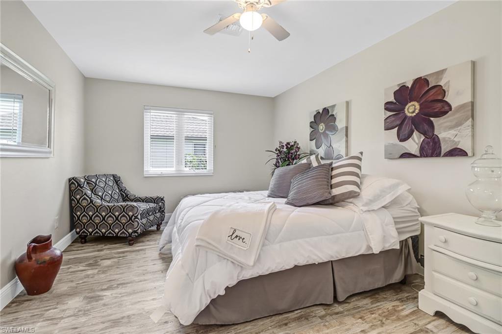 148 Pebble Beach Boulevard Naples, FL 34113 - Photo 17 of 24 a bedroom with a bed and a chandelier