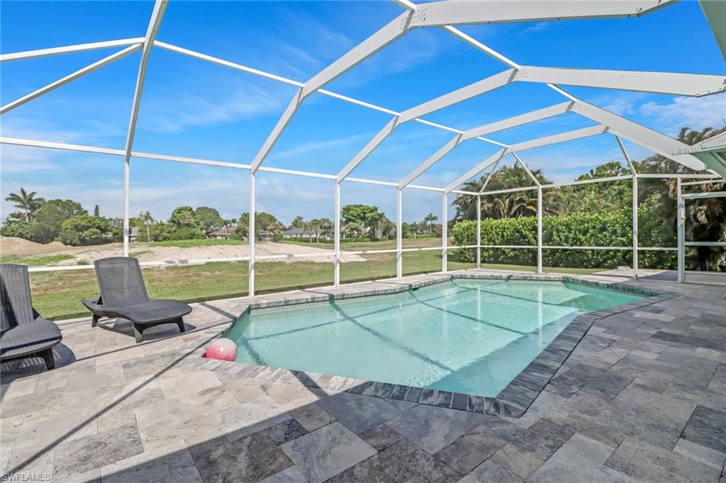 148 Pebble Beach Boulevard Naples, FL 34113 - Photo 19 of 24 a view of a backyard with a swimming pool