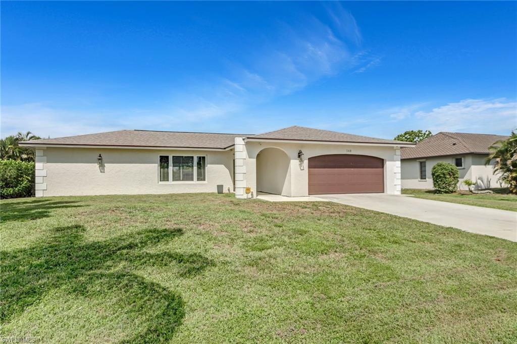148 Pebble Beach Boulevard Naples, FL 34113 - Photo 23 of 24 a house view with a garden space