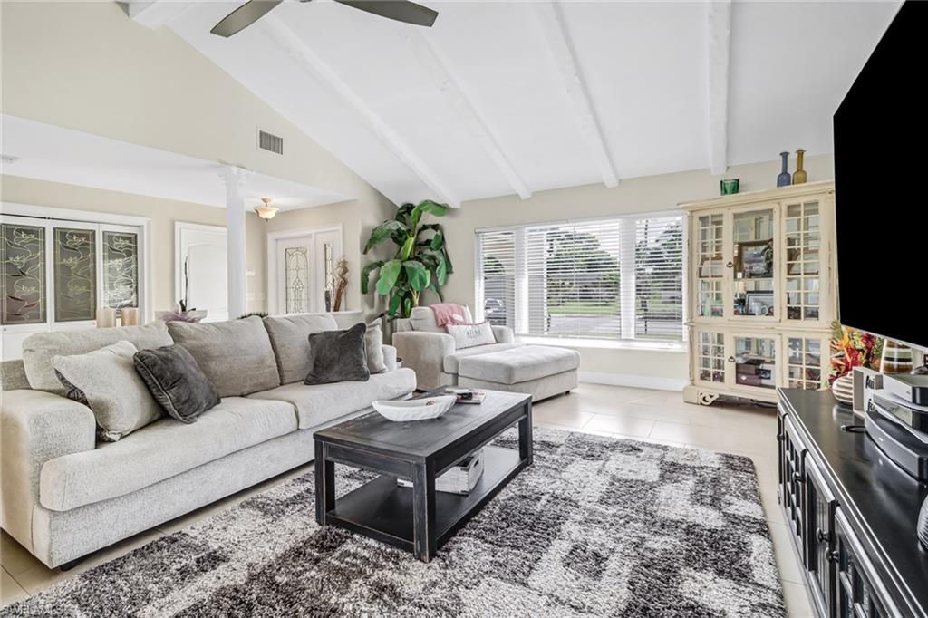 148 Pebble Beach Boulevard Naples, FL 34113 - Photo 3 of 24 a living room with furniture a flat screen tv and a fireplace