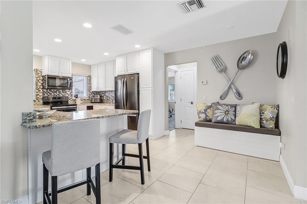 148 Pebble Beach Boulevard Naples, FL 34113 - Photo 6 of 24 a kitchen with stainless steel appliances a refrigerator sink and stove