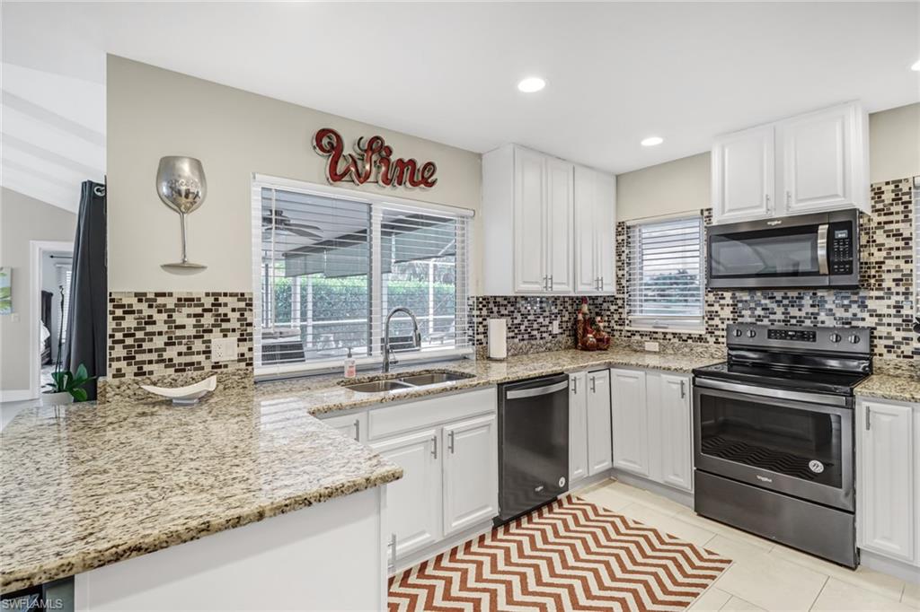 148 Pebble Beach Boulevard Naples, FL 34113 - Photo 8 of 24 a kitchen with stainless steel appliances kitchen island granite countertop a sink stove and cabinets